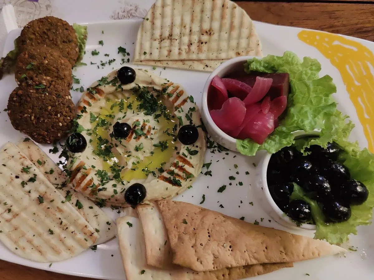 Falafel, hummus, pickles and grilled pita on a platter